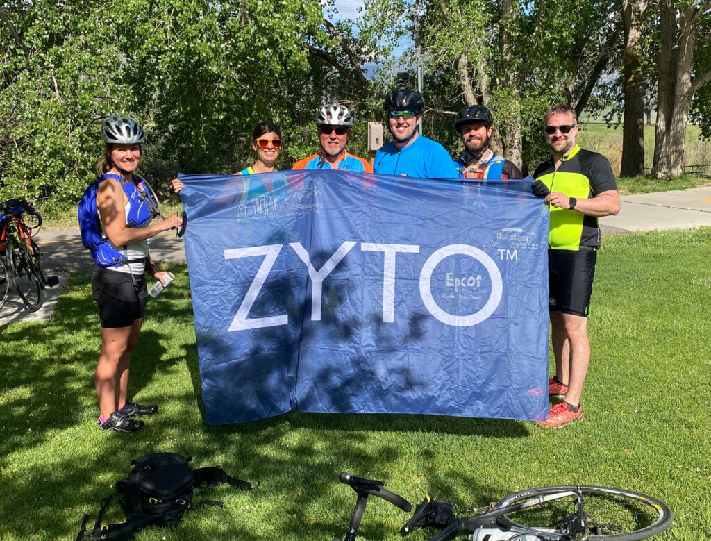 employees holding zyto flag after bike ride