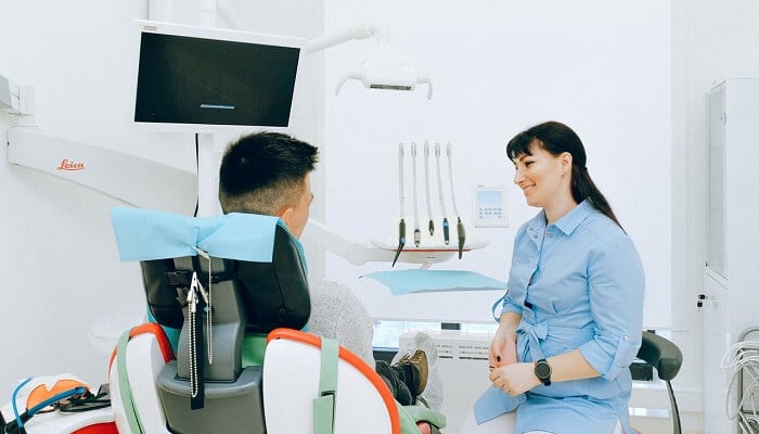 dentist talking to client in dental chair