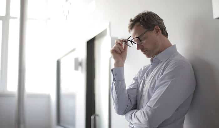 stressed-out man removing glasses