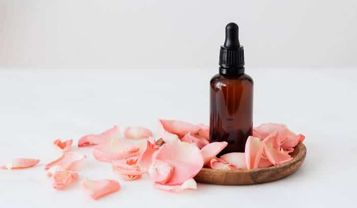 essential oil bottle next to flowers
