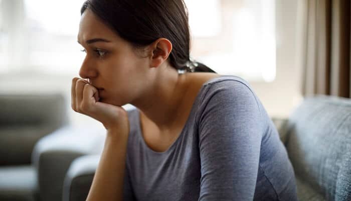 troubled woman on sofa experiencing guilt