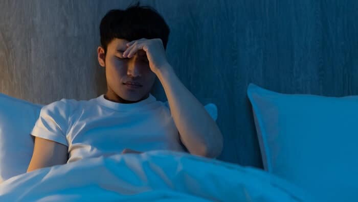 young man in bed can't sleep