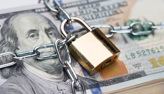 lock and chain around $100 bills - financial security concept