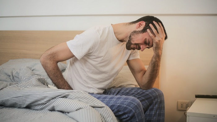 man waking up in pain