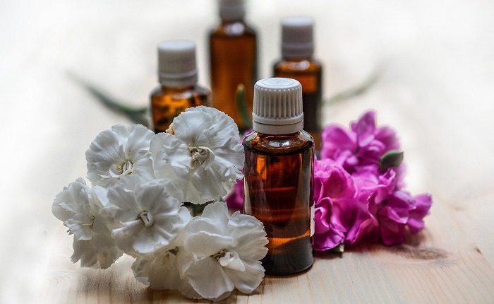 essential oil bottles next to flowers