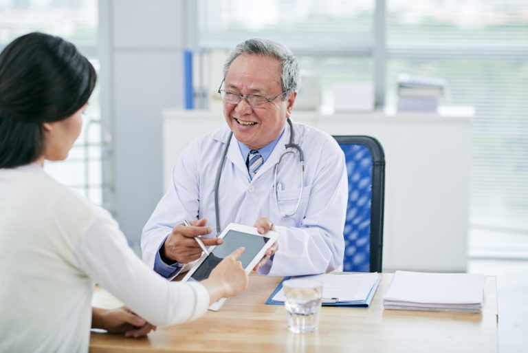 smiling experienced doctor talking to patient