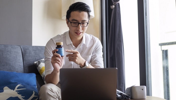 young man pointing to supplement during virtual consultation