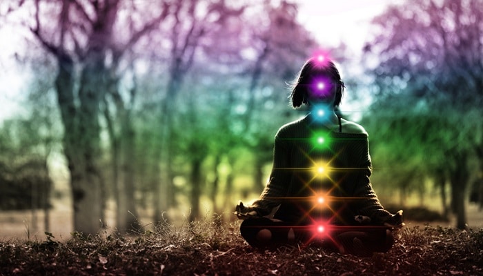 chakras shown on woman meditating in the woods