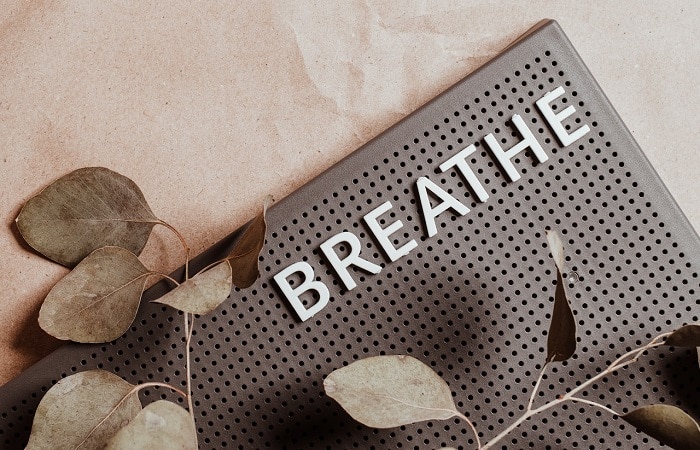breathe written on mat next to leaves