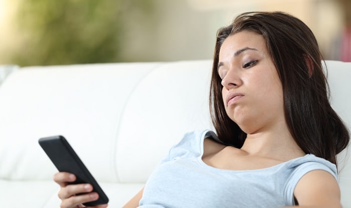 frustrated young woman looking at cell phone