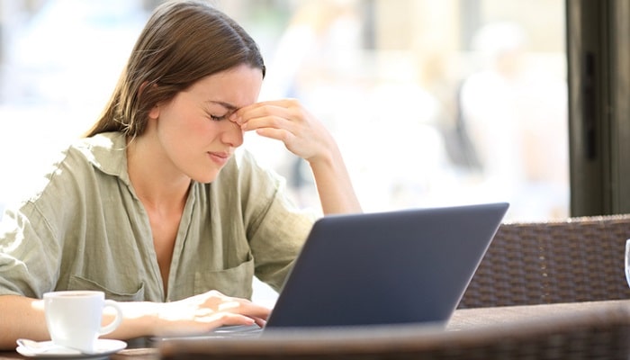 woman getting headache from working on laptop
