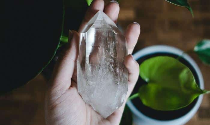 holding a clear quartz crystal