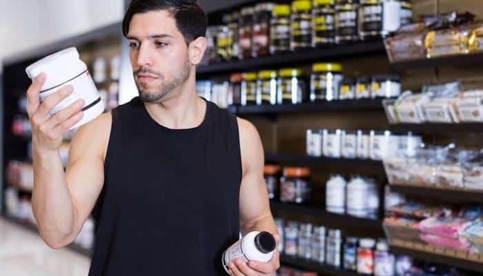 ripped young man shopping for supplements