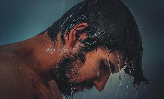 man rinsing hair in shower