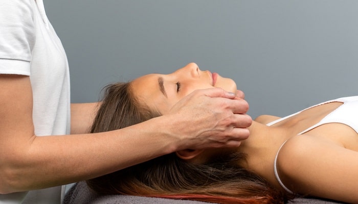 practitioner doing tmj therapy on young girl