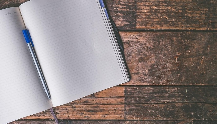 notebook and pen on wood floor