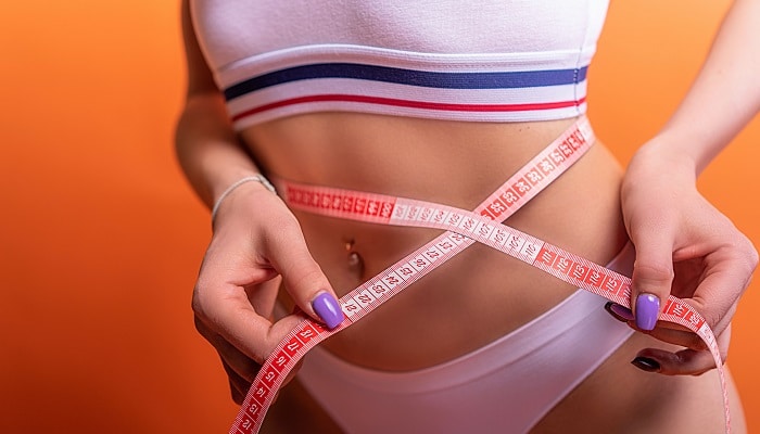 woman measuring waistline