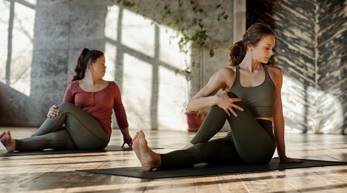 women doing sitting yoga stretch