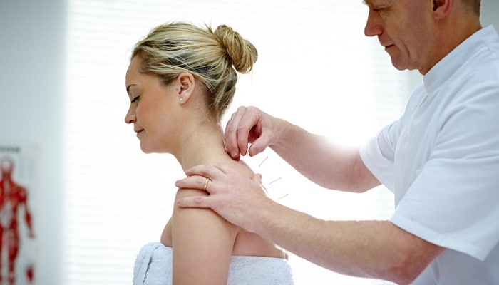Male Acupuncturist Treating Female Patient