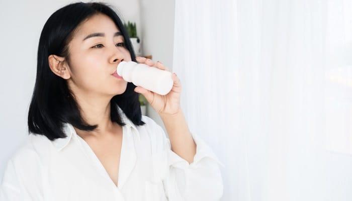 woman drinking probiotic beverage