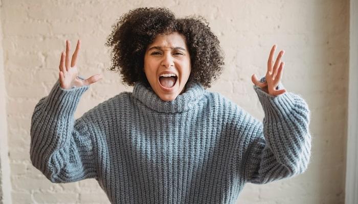 young woman raising hands in anger
