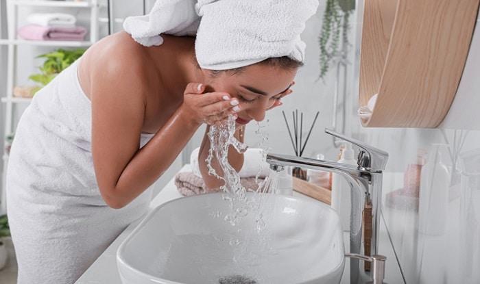 young woman washing her face in the bathroom