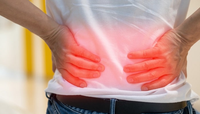 man holding sore back in need of essential oils for back pain