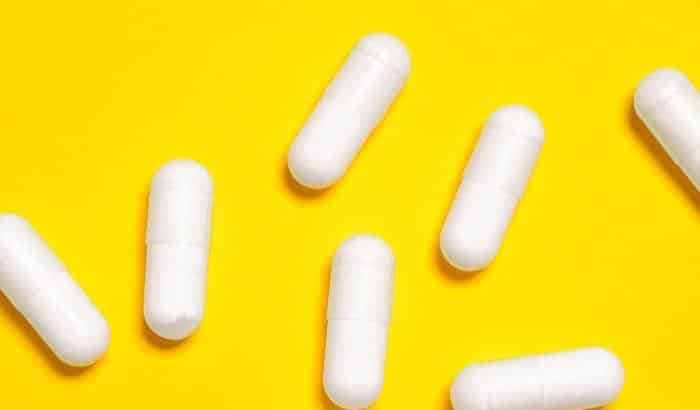 white l-serine pills on yellow background