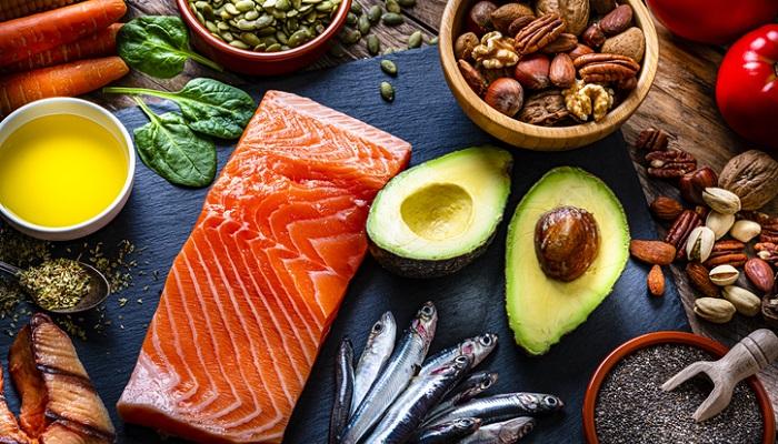 foods high in omega 3 - salmon and avocado next to nuts and seeds