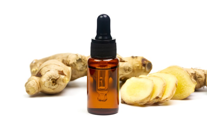ginger root next to essential oil bottle