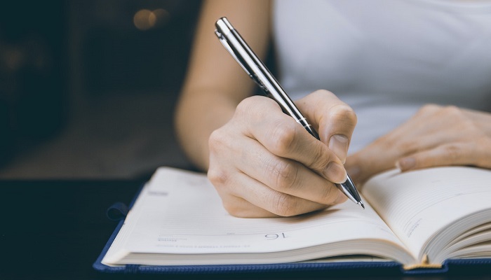 woman writing down nutrition questions to ask in journal