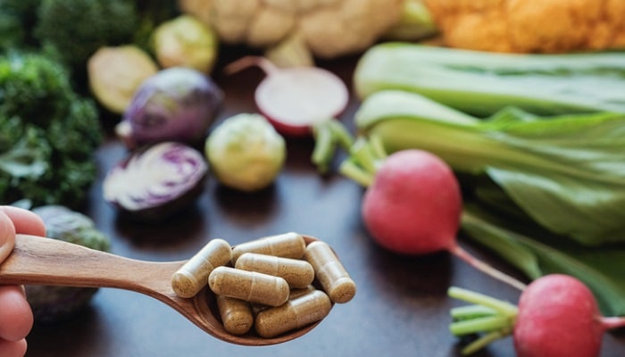 fiber pills on spoon with vegetables