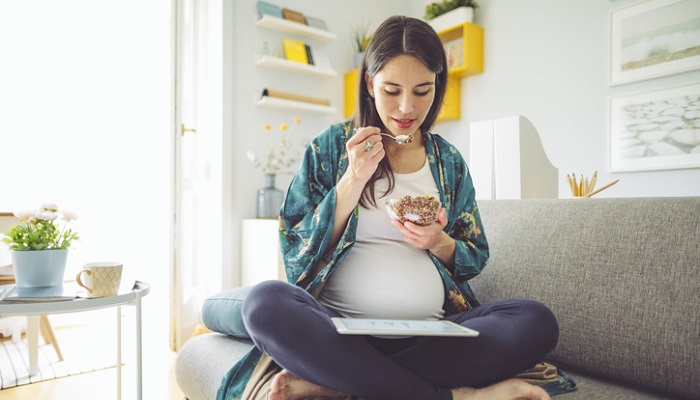 expecting mother eating granola - best foods for pregnancy