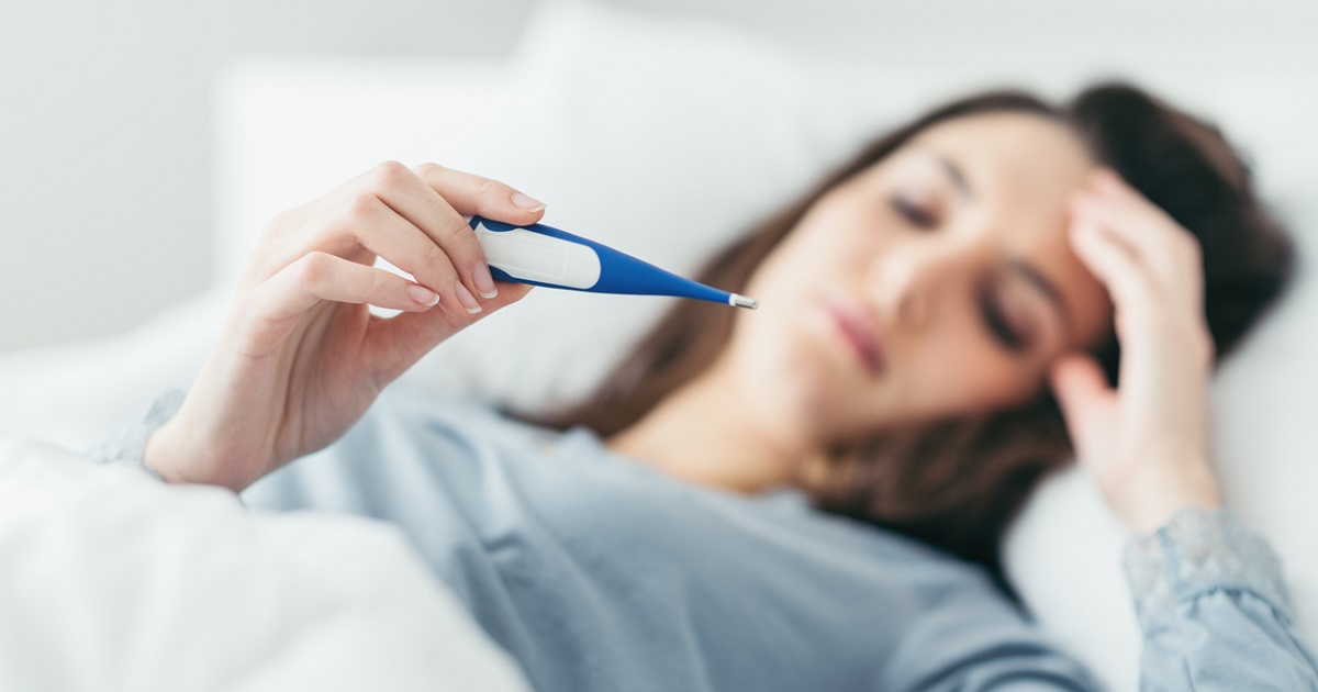 woman in bed considering essential oils for fever