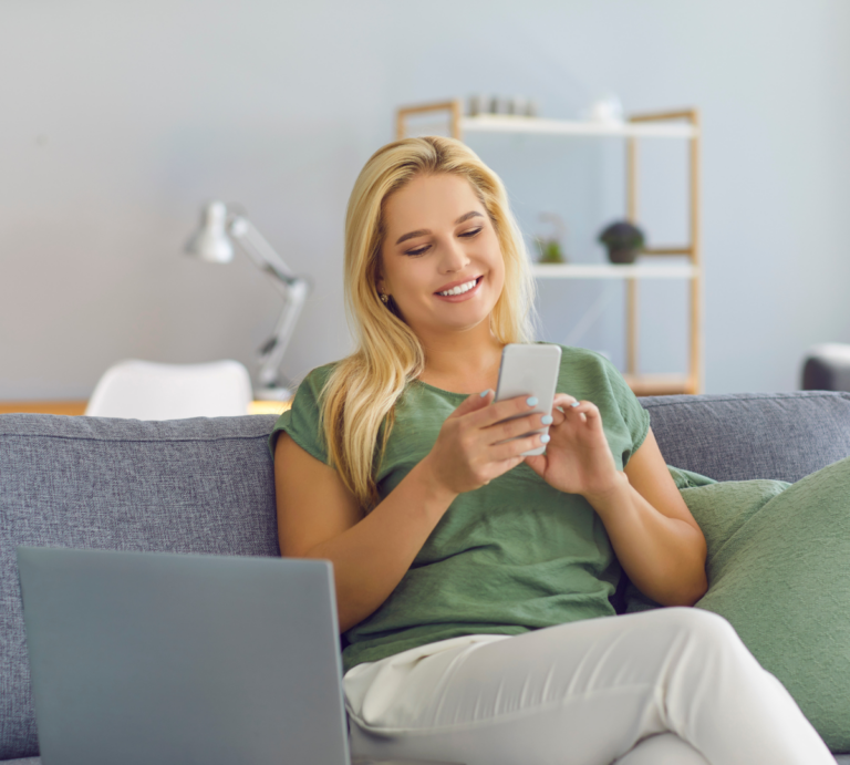 happy woman on couch looking at phone