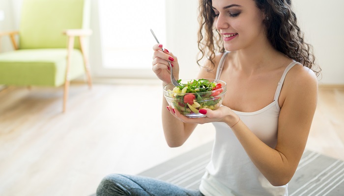 happy young woman eating salad