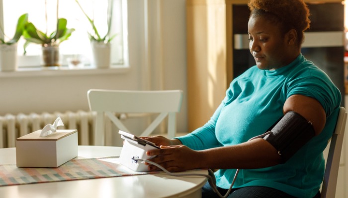 woman measuring blood pressure at home