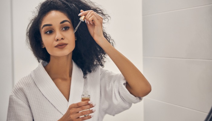 young woman applying essential oils for skin tightening