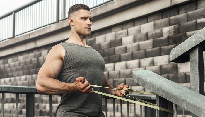 man doing rowing exercise with resistance band