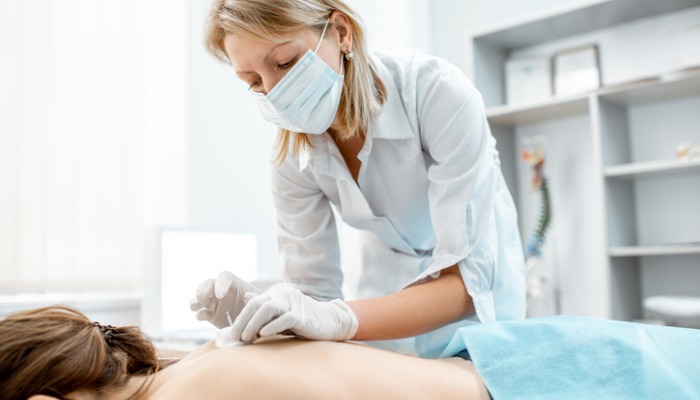 acupuncturist placing needs on conception meridian point