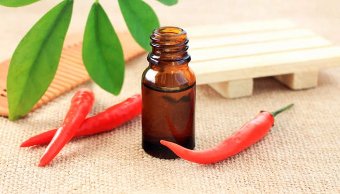 cayenne peppers next to essential oil bottle