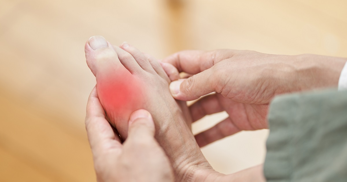 painful gout - man holding foot