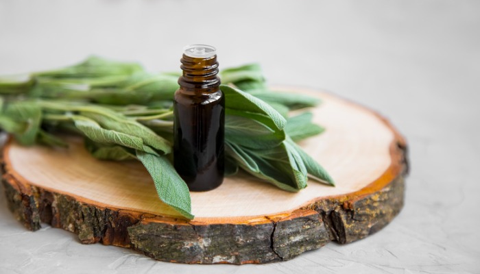 sage leaves and essential oil on wood