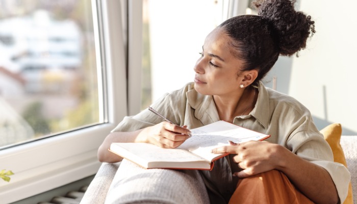 young woman writing in journal