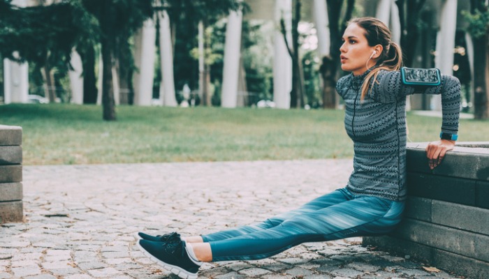 young woman doing tricep dips in the park
