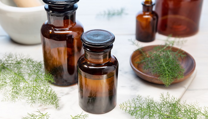 fennel leaves next to essential oil bottles