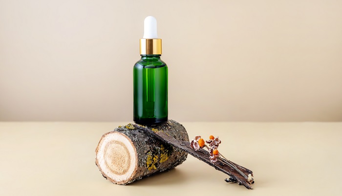 essential oil bottle on top of oak branch