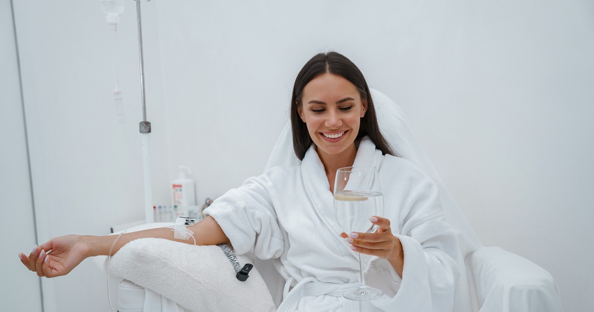 smiling woman getting IV treatment for migraines