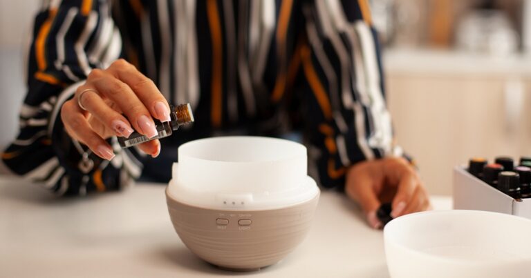 pouring essential oil into diffuser