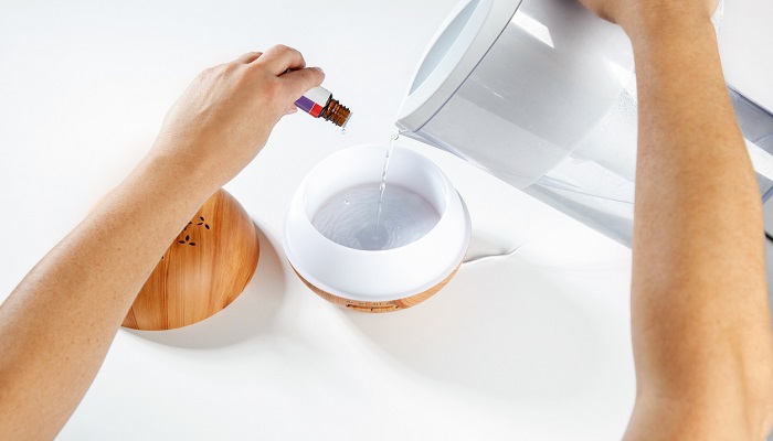 pouring water and essential oil into diffuser